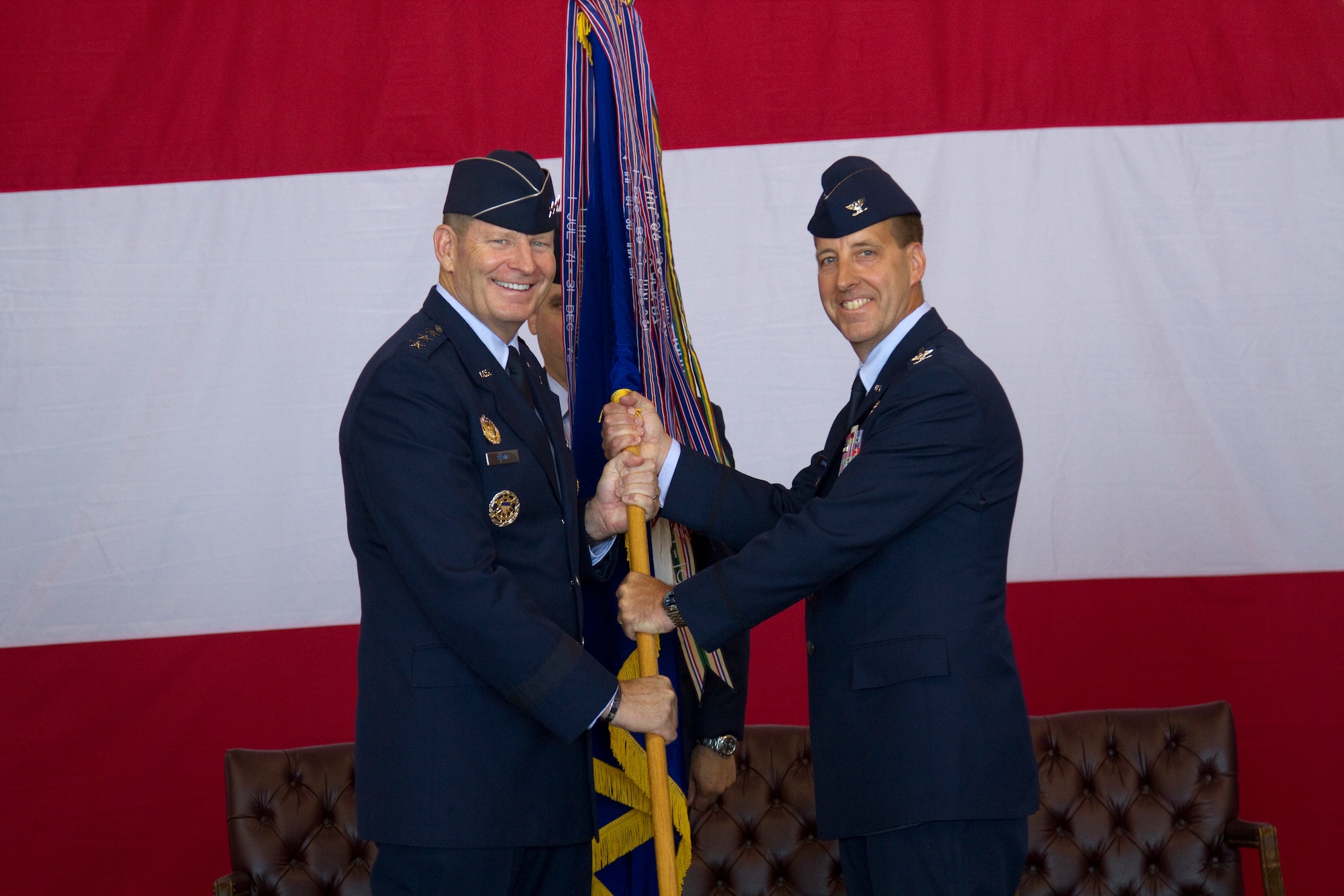 The commander of 12th Air Force (Air Forces Southern), Lt. Gen. Robin Rand (left), passes the 552nd Air Control Wing guidon to Col. Jay Bickley and with it, command of the 552nd ACW at a ceremony at Tinker Air Force Base, June 13.  Colonel Bickley replaced departing commander, Col. Gregory Guillot who will lead the 55th Wing at Offutt Air Force Base, Neb. (U.S. Air Force Photo/Master Sgt. Thomas Edwards)