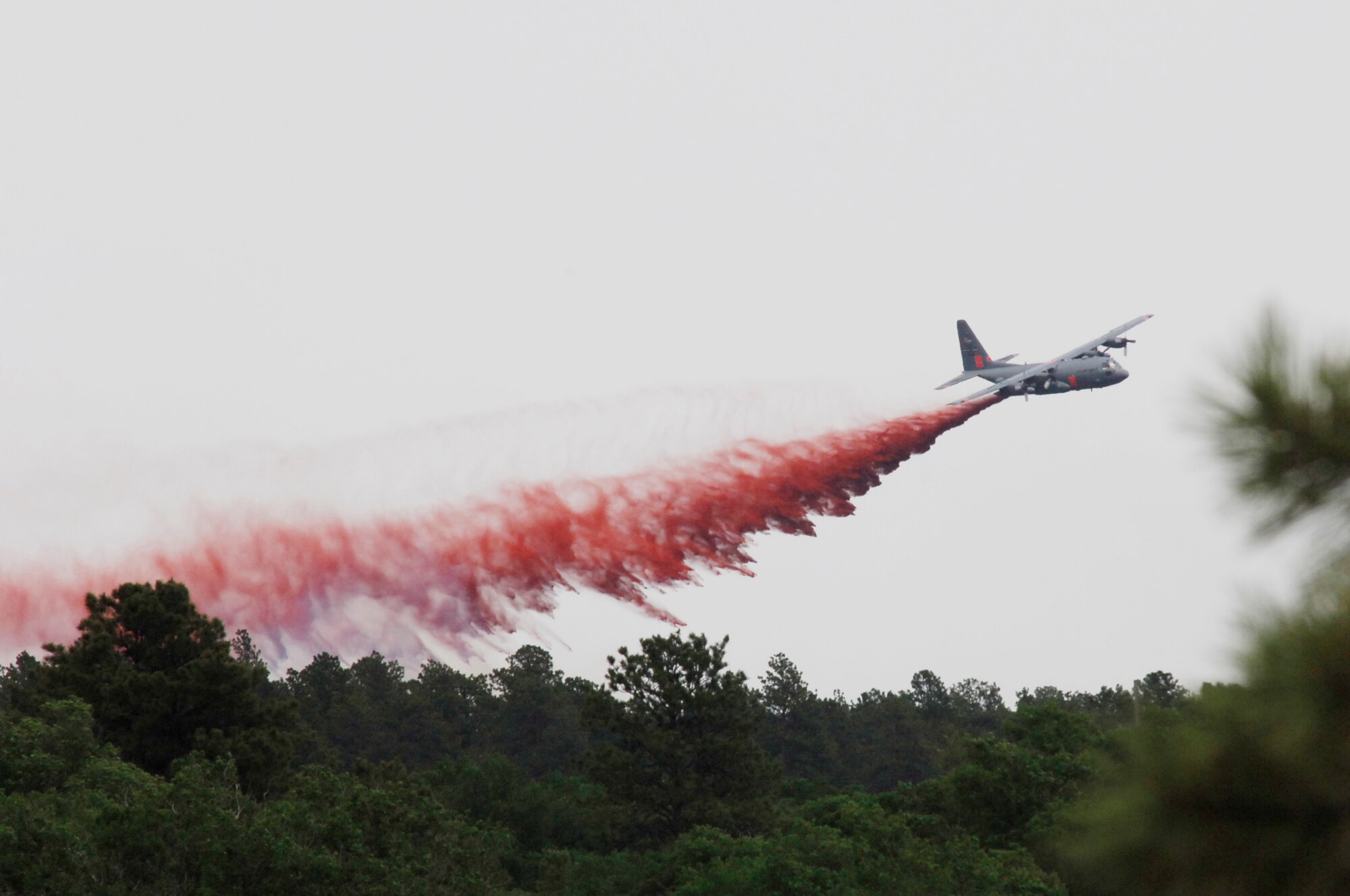 An aircraft releases a fire-retardant solution to help stop the spreading of the burning fires at Black Forest, Colo., June 12, 2013. (U.S. Air Force photo by Senior Airman Kendra Alba)