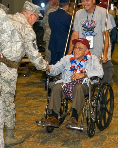 A member of the 182nd Airlift Wing greets a U.S. Armed Forces veteran after his return home from the inaugural Greater Peoria Honor Flight at the General Wayne A. Downing Peoria International Airport in Peoria, Ill., June 4, 2013.  American war veterans and their volunteer guardians were flown from Peoria to Washington, D.C., in order to see their respective memorials in person before age and disability would make it impossible to do so later.  That evening, members of the Illinois Air National Guard’s 182nd Airlift Wing and other current service members gathered at the airport terminal in uniform to personally welcome the veterans home and honor their service.  (U.S. Air National Guard photo by Staff Sgt. Lealan Buehrer/Released)