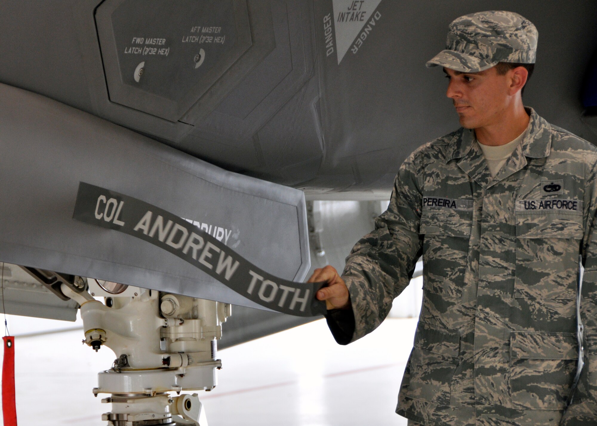 Staff Sgt. Danny Pereira, of the 33rd Aircraft Maintenance Squadron unveils Col. Todd Canterbury's flagship on an F-35A Lightning II during the 33rd Fighter Wing's change of command ceremony June 14 at Eglin Air Force Base, Fla. Canterbury took command of the wing from Col. Andrew Toth, who leaves to become director of assignments at Joint Base San Antonio-Randolph, Texas. (U.S. Air Force photo/Sara Vidoni)