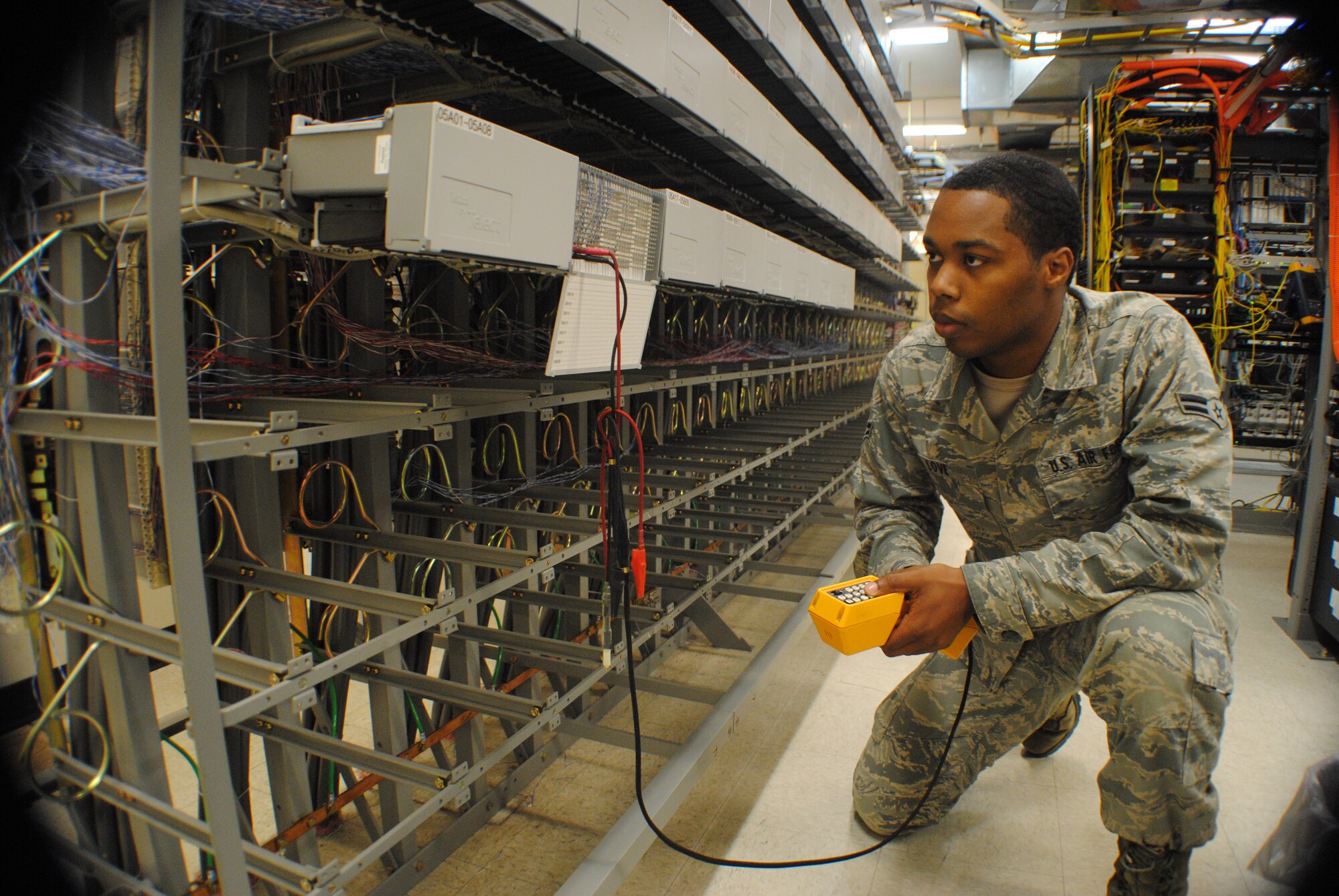 Airman 1st Class Xavier Love, 319th Communications Squadron, uses a lineman’s handset to check the activation of a telephone line at Grand Forks Air Force Base, N.D., on May 30, 2013. Approximately 3,000 telephone lines are used as part of the installation’s computer network. (U.S. Air force photo/Staff Sgt. Luis Loza Gutierrez)