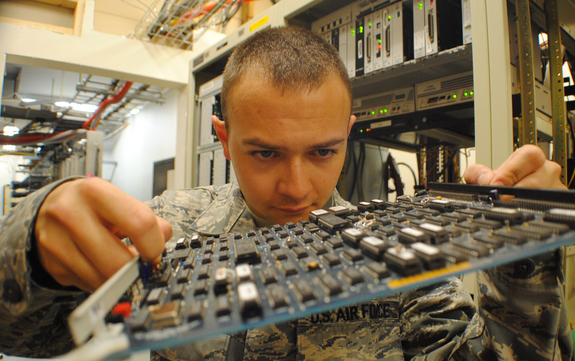 Airman 1st Class Taylor Simmons, 319th Communications Squadron, inspects a computer motherboard at Grand Forks Air Force Base, N.D., on May 30, 2013. Cyber transport systems technicians such as Simmons are responsible for maintaining the computer networks used on base for routine communication tasks such as e-mail and internet connectivity.(U.S. Air force photo/Staff Sgt. Luis Loza Gutierrez)