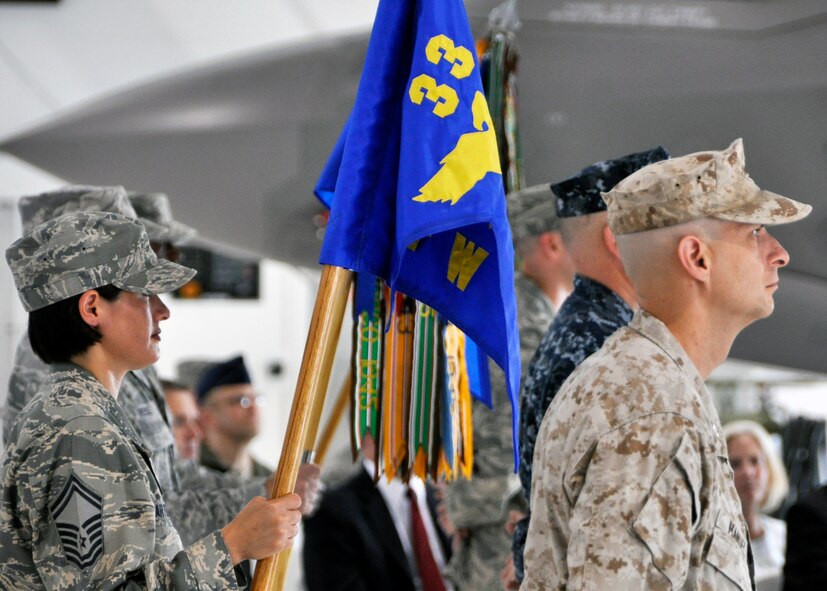 Group commanders line up with their guidons prior to the 33rd Fighter Wing change of command ceremony June 14 at Eglin Air Force Base, Fla. From the left, Senior Master Sgt. Martinez holds the colors for the Academic Training Center and stands behind their group commander, Marine Col. Anthony Manuel. To their left are the 33rd Maintenance Group led by Navy Capt. Lance Massey and the 33rd Operations Group led by Col. Stephen Jost. While the wing will always be led by an Air Force colonel, other senior leadership positions rotate among the three co-located services who are part of the team managing the F-35 Lightning II Integrated Training Center for the U.S. military and its coalition partners. Col. Todd Canterbury took command of the wing from Col. Andrew Toth, who leaves to become director of assignments at Randolph Air Force Base in San Antonio, Texas. (U.S. Air Force photo/Sara Vidoni)