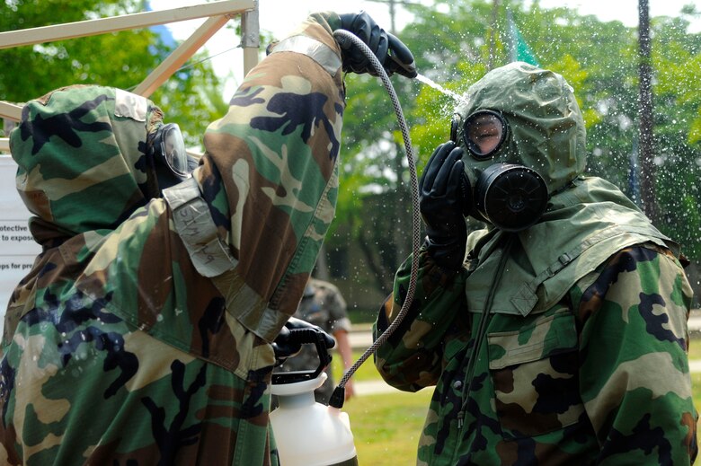 Staff Sgt. Shaun Renn assists an airman assigned to South Korea’s 38th Fighter Group with the mask washing decontamination station during the simulated chemical, biological, radiological and nuclear attack exercise June 5, 2013, at Kunsan Air Base, South Korea. South Korean airmen had the opportunity to walk through each station during the exercise, giving them a chance to learn new tactics, techniques and procedures. Renn is an emergency management journeyman assigned to the 8th Civil Engineer Squadron. (U.S. Air Force photo/Senior Airman Jessica Haas)