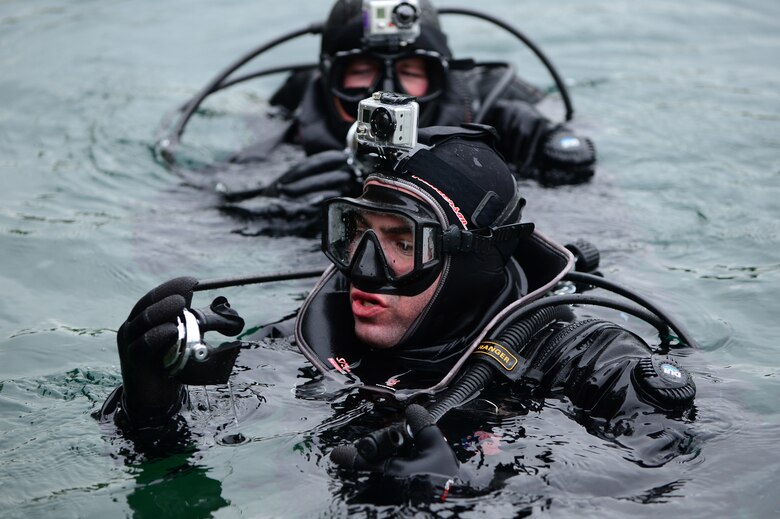 Staff Sgt. Kent Swats (front) and Senior Airman Chris Sanders perform checks prior to submersion during rescue dive training May 30, 2013, in Stoney Cove, England. Before, during and after the dive, the individuals are briefed, run through scenarios, and perform equipment checks. Swats and Sanders are pararescuemen assigned to the 56th Rescue Squadron. (U.S. Air Force photo/Senior Airman Lausanne Morgan)