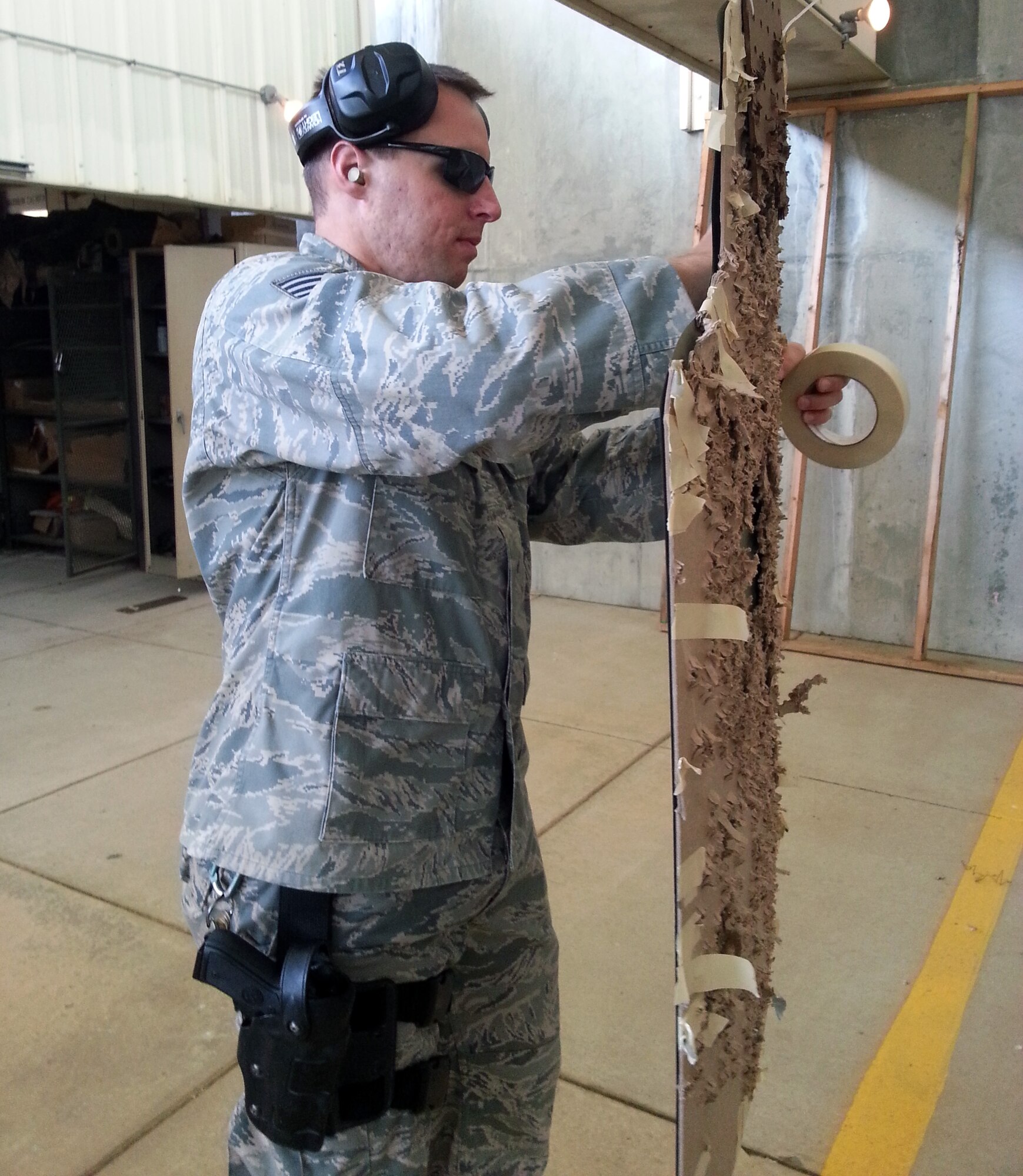 Staff Sgt. Joseph Aaron, a combat arms training and maintenance instructor assigned to the 931st Security Forces Squadron, McConnell Air Force Base, Kan., attaches a target at the McConnell Air Force Base arms qualification range, June 14, 2013.  Instructors like Aaron teach Airmen skills that allow them to qualify on the M-4 rifle and M-9 pistol. (U.S. Air Force photo by Capt. Zach Anderson)