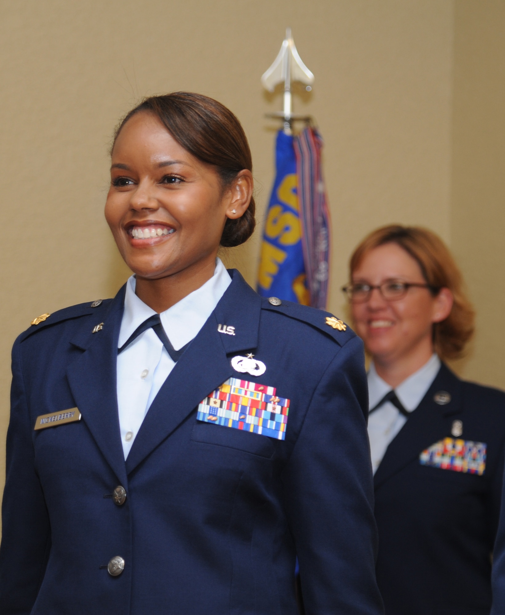 Maj. Sharon Nickelberry, incoming 81st Force Support Squadron commander, smiles as she prepares to sing the Air Force song following the 81st FSS change of command ceremony as Master Sgt. Traci Devereaux, 81st FSS first sergeant, stands-by during the 81st FSS change of command ceremony June 14, 2013, at the Bay Breeze Event Center, Keesler Air Force Base, Miss.  Col. Mark Vivians, 81st Mission Support Group Commander, served as the presiding officer for the event.  (U.S. Air Force photo by Kemberly Groue)