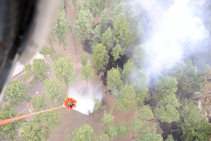 The crew of a UH-60 Black Hawk helicopter releases a load of water to protect a structure in advance of the Black Forest Fire June 13, 2013. The fire had killed two people, burned 15,700 acres and destroyed 379 homes as of June 14. (U.S. Air Force photo/Capt. Richard Ricciardi)