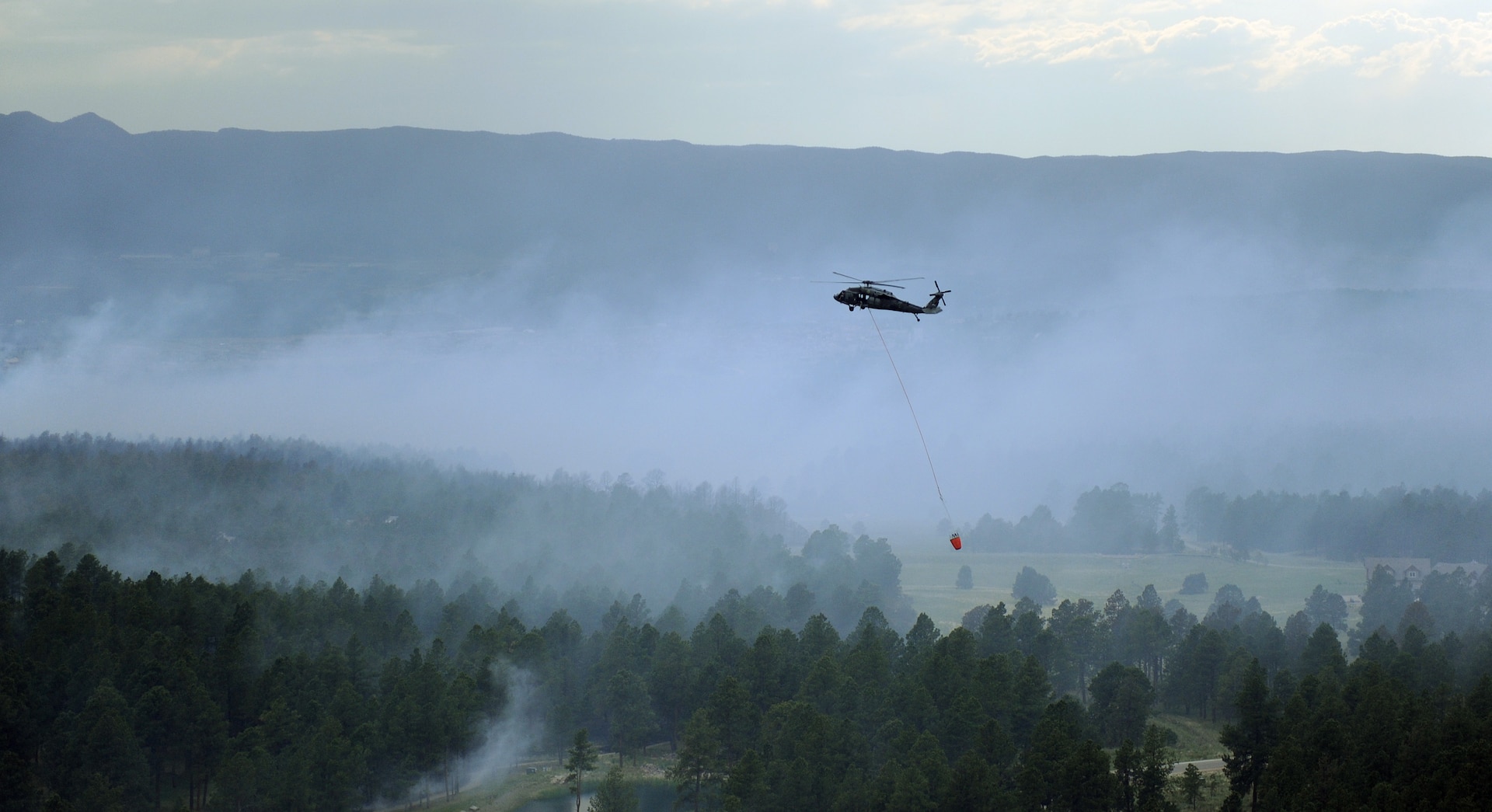 A UH-60 Black Hawk helicopter carries water over the Black Forest Fire June 13, 2013. Two Black Hawks and two CH-47 Chinooks are using the Air Force Academy Airfield as a refueling and staging area for ongoing firefighting operations. (U.S. Air Force photo/Capt. Richard Ricciardi)