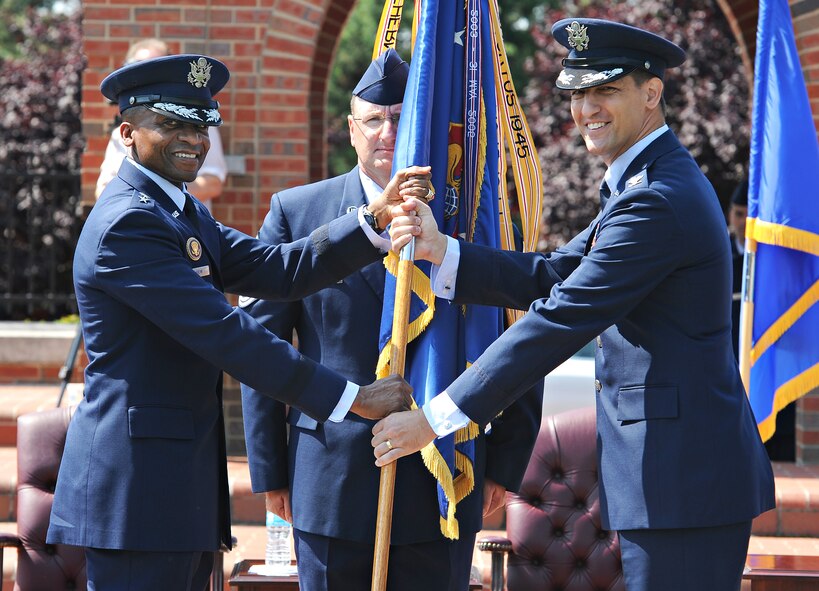 Lt. Gen. Darren McDew, 18th Air Force commander, presents the 375th Air Mobility Wing flag to Col. Kyle Kremer signifying the start of Kremer's command of the wing during a ceremony June 14 at Scott Air Force Base, Ill. Kremer arrived from McConnell Air Force Base, Kan., where he served as the vice commander of the 22nd Air Refueling Wing. (U.S. Air Force photo/Airman Kristina Forst)