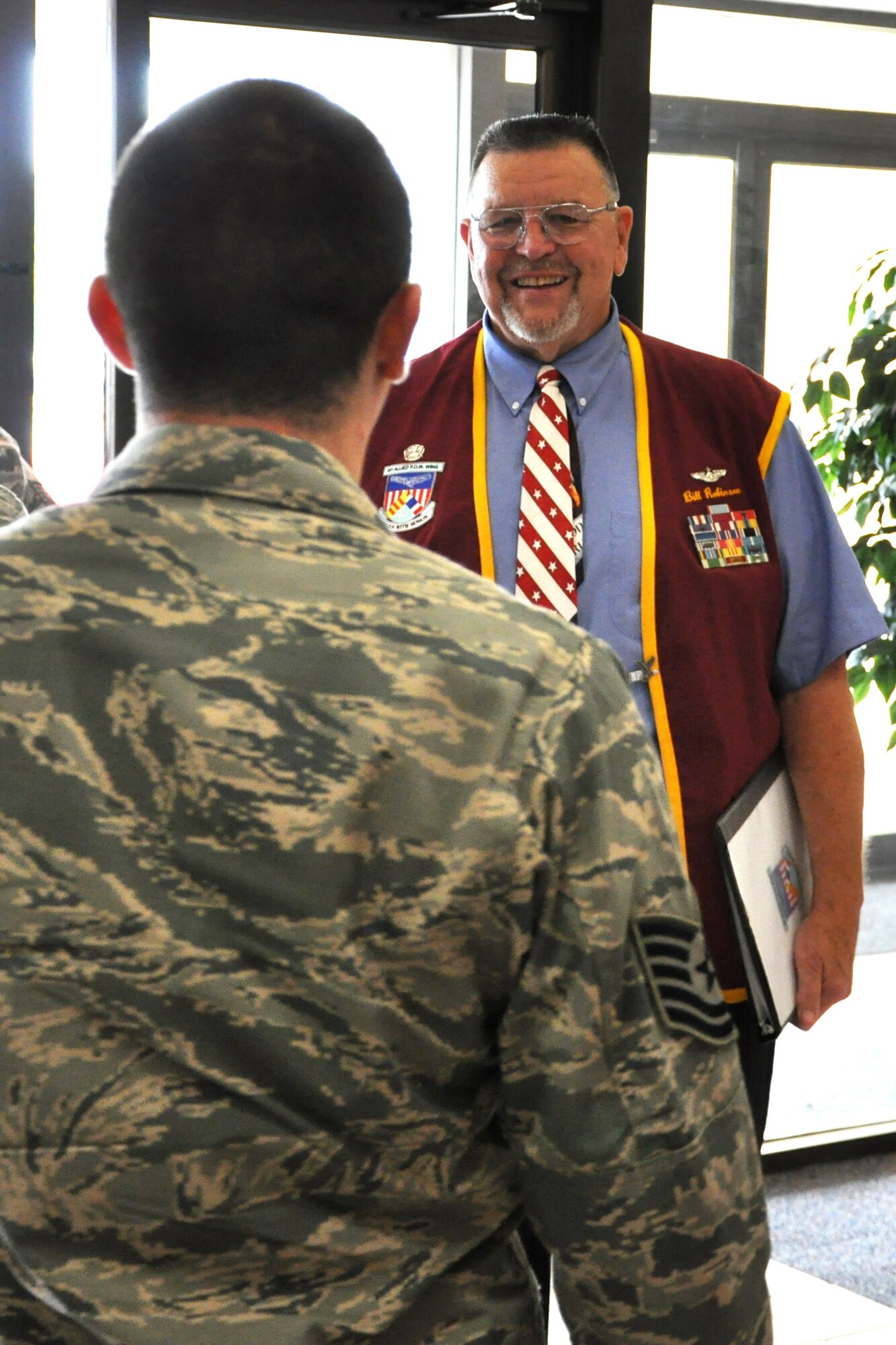 Retired Capt. William Robinson smiles as he waits to talk with each of the individual students of Airey NCO Academy lined up to meet him June 6 in the academy’s foyer. He had just shared his story with an auditorium full of students.  Captain Robinson is the longest held enlisted prisoner of war in American history and is one of three Air Force enlisted men to ever receive a direct commission to Lieutenant from the president of the United States. (U.S. Air Force photo by Airman 1st Class Alex Echols)