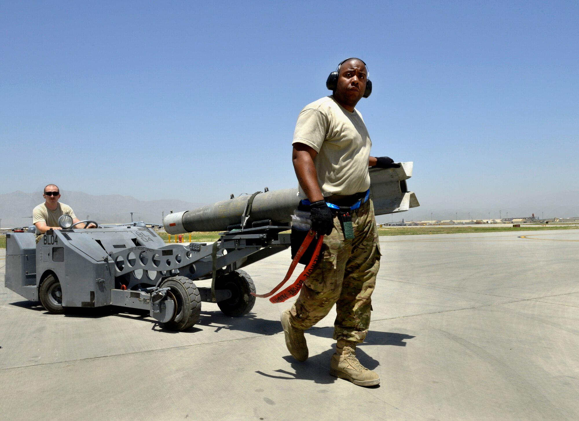 Staff Sgt. Rashid Harris, 455th Expeditionary Aircraft Maintenance Squadron weapons load crew chief, directs the Jammer as it loads a cluster bomb into place on an A-10C Thunderbolt II aircraft on Bagram Airfield, Afghanistan, June 11. Harris and the aircraft are deployed from Moody Air Force Base, Ga. The A-10 Thunderbolt II has excellent maneuverability at low air speeds and altitude and is a highly accurate and survivable weapons-delivery platform.  (U.S. Air Force photo/ Staff Sgt. Stephenie Wade)