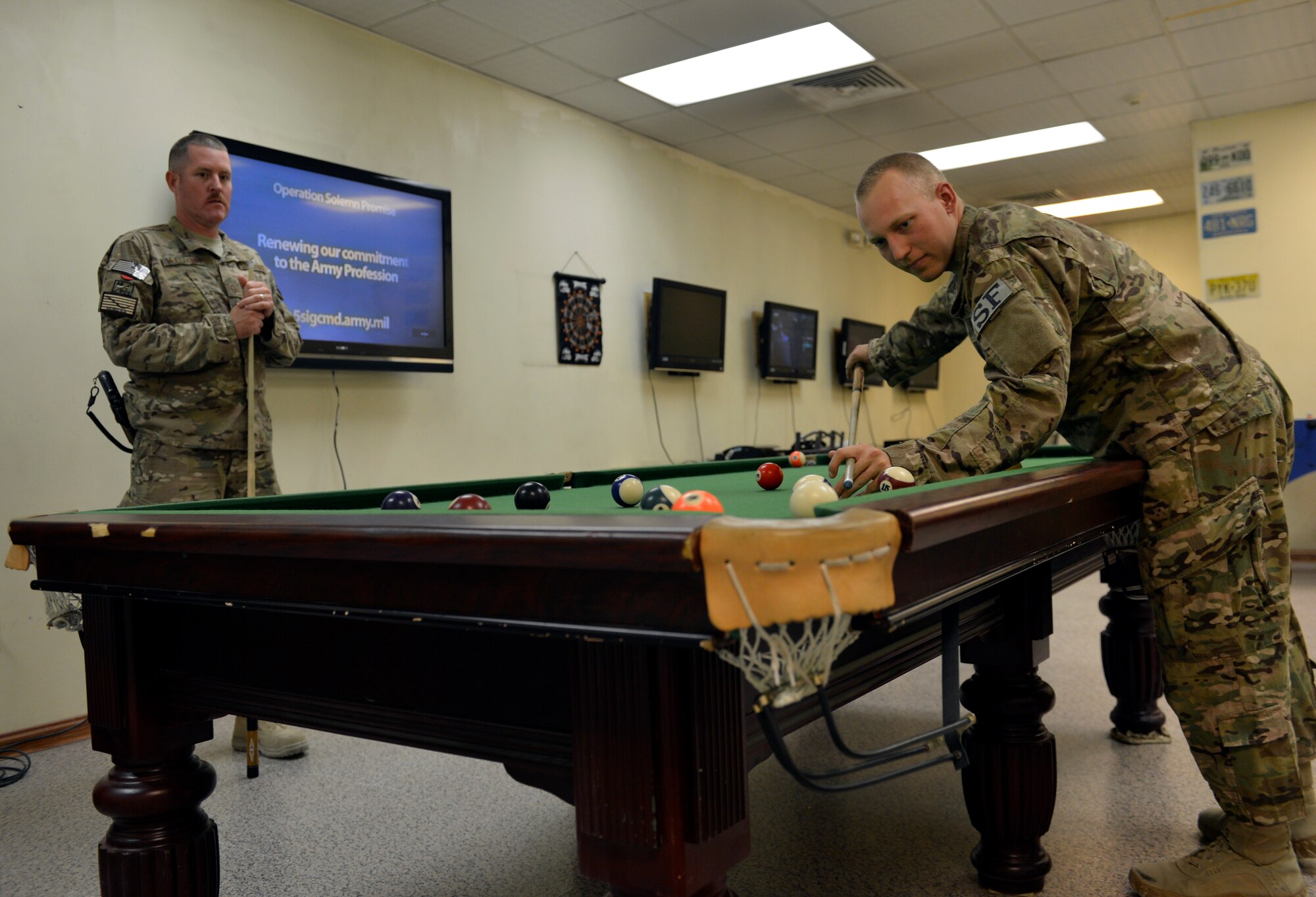 Master Sgt. Gregory McElvaney plays pool with his stepson Airman 1st Class Tyler Mills in the Moral and Recreation center on Bagram Airfield, Afghanistan June 6. McElvaney is assigned to Regional Command East Joint Theater Trauma Center and Mills is assigned to the 455th Expeditionary Security Force Squadron. (U.S. Air Force photo/ Staff Sgt. Stephenie Wade)