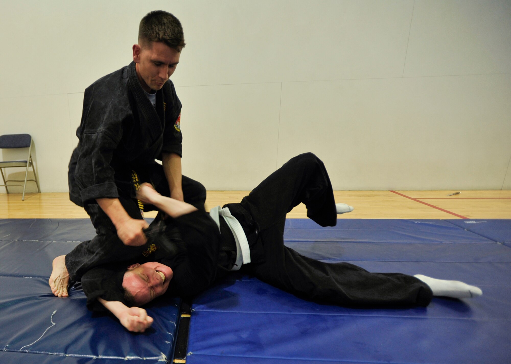 Tech. Sgt. Thomas Locke, Combat Hapkido instructor and 694th Intelligence Support Squadron policy and evaluations inspector, grasps the gi of Tech. Sgt. Ian Bobnes, 694th ISS quality assurance technician, after tossing him on the mat during a Combat Hapkido class at Osan Air Base, Republic of Korea, May 29, 2013. Combat Hapkido is a self-defense system that’s not constrained by any rules or boundaries like other martial arts. Classes are held at the Osan Fitness Center every Monday and Wednesday from 7-9 p.m. (U.S. Air Force photo/Senior Airman Siuta B. Ika)