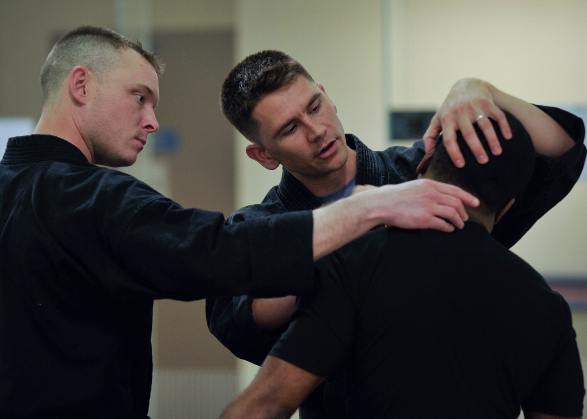 Tech. Sgt. Thomas Locke (center) shows Tech. Sgt. Ian Bobnes a pressure point on the neck of Staff Sgt. Ricardo Gray during a Combat Hapkido class at Osan Air Base, Republic of Korea, May 29, 2013. The structure and a lot of the techniques used in Combat Hapkido – like joint locks and the self-defense mind set – derive from traditional Hapkido, but Combat Hapkido is inclusive of many different martial arts. Locke is a Combat Hapkido instructor and a 694th Intelligence Support Squadron policy and evaluations inspector, Bobnes is a quality assurance technician with the 694th ISS, and Gray is a orthopedic surgical technician with the 51st Medical Operations Squadron. (U.S. Air Force photo/Senior Airman Siuta B. Ika)