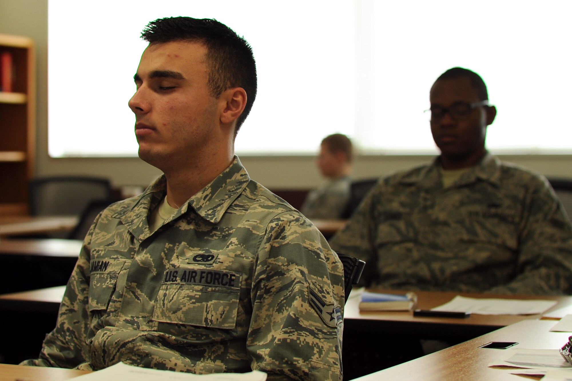 YOKOTA AIR BASE, Japan -- Airman 1st Class Brian Jamian, 374th Maintenance Squadron, and Airman 1st Class Daniel Striggles, 374th Logistics Readiness Squadron, practice meditation June 14, 2013, during resiliency training at Yokota Air Base, Japan. The new training teaches skills based upon the four Airmen Comprehensive Fitness domains: mental, social, physical and spiritual. (U.S. Air Force photo by Senior Airman Desiree Economides)