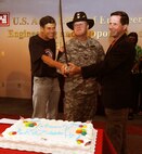 U.S. Army Engineering and Support Center, Huntsville commander Col. Robert Ruch, traditionally flanked by the longest serving Huntsville Center employee, Larry McIntosh (left), and the Center's newest employee Russ Dunford, celebrated the Army's 238th Birthday by cutting the birthday cake. McIntosh has been with the Corps of Engineers for 38 years. Dunford joined the Corps of Engineers two weeks ago.