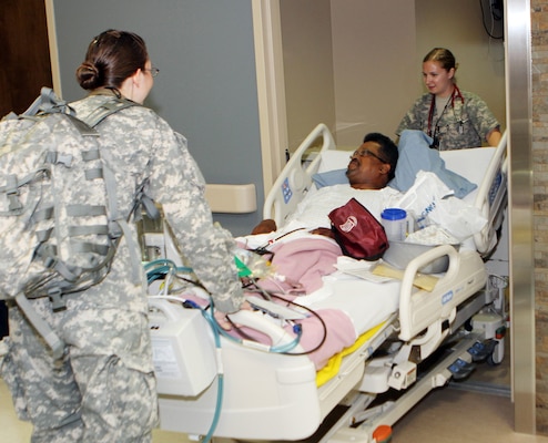 Nurses 1st Lt. Juliane Case, left and 1st Lt. Liana Gates wheel patient James Heckard into his room on the new fourth floor Inpatient Family Care Ward at the Evans Army Medical Center in Fort Carson, Colo.