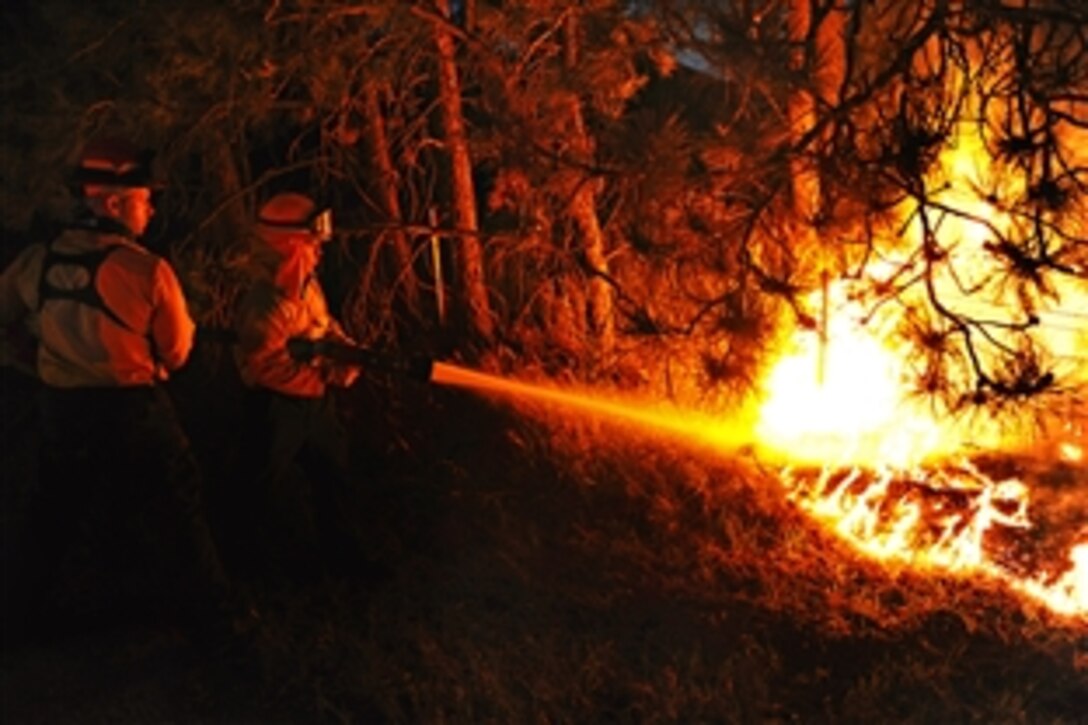 Air Force Academy firefighters battle a hotspot in the Black Forest Fire in Colorado Springs, Colo., June 12, 2013. A total of 16 personnel and five vehicles from the Academy have deployed to fight the fire, which has burned hundreds of homes and consumed thousands of acres. 