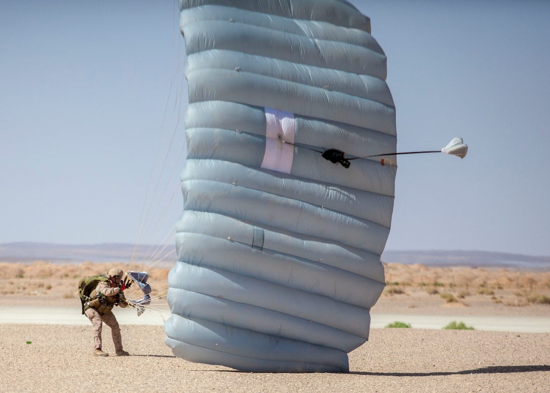 A 26th Marine Expeditionary Unit (MEU) Maritime Raid Force Marine draws in his parachute during parachute operations at King Faisal Air Base in Jordan, June 12, 2013. Exercise Eager Lion 2013 is an annual, multinational exercise designed to strengthen military-to-military relationships and enhance security and stability in the region by responding to modern-day security scenarios. The 26th MEU is a Marine Air-Ground Task Force forward-deployed to the U.S. 5th Fleet area of responsibility aboard the Kearsarge Amphibious Ready Group serving as a sea-based, expeditionary crisis response force capable of conducting amphibious operations across the full range of military operations. (U.S. Marine Corps photograph by Sgt. Christopher Q. Stone, 26th MEU Combat Camera/Released)