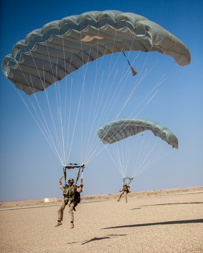 26th Marine Expeditionary Unit (MEU) Maritime Raid Force Marines descend to a landing zone during parachute operations at King Faisal Air Base in Jordan, June 12, 2013. Exercise Eager Lion 2013 is an annual, multinational exercise designed to strengthen military-to-military relationships and enhance security and stability in the region by responding to modern-day security scenarios. The 26th MEU is a Marine Air-Ground Task Force forward-deployed to the U.S. 5th Fleet area of responsibility aboard the Kearsarge Amphibious Ready Group serving as a sea-based, expeditionary crisis response force capable of conducting amphibious operations across the full range of military operations. (U.S. Marine Corps photograph by Sgt. Christopher Q. Stone, 26th MEU Combat Camera/Released)