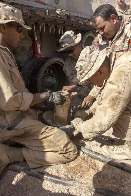 U.S. Marines assigned to Combat Logistics Battalion 26 and Battalion Landing Team 3/2, 26th Marine Expeditionary Unit (MEU), and a member of the Jordanian Armed Forces prepare a replacement support roller in efforts to fix damaged tracks of a Jordanian Armed Forces M88A1 during Exercise Eager Lion 2013 in Al Quweira, Jordan, June 13, 2013. Exercise Eager Lion 2013 is an annual multinational exercise designed to strengthen military-to-military relationships and enhance security and stability in the region. The 26th MEU is a Marine Air-Ground Task Force forward-deployed to the U.S. 5th Fleet area of responsibility aboard the Kearsarge Amphibious Ready Group serving as a sea-based, expeditionary crisis response force capable of conducting amphibious operations across the full range of military operations. (U.S. Marine Corps photo by Cpl. Kyle N. Runnels/Released)