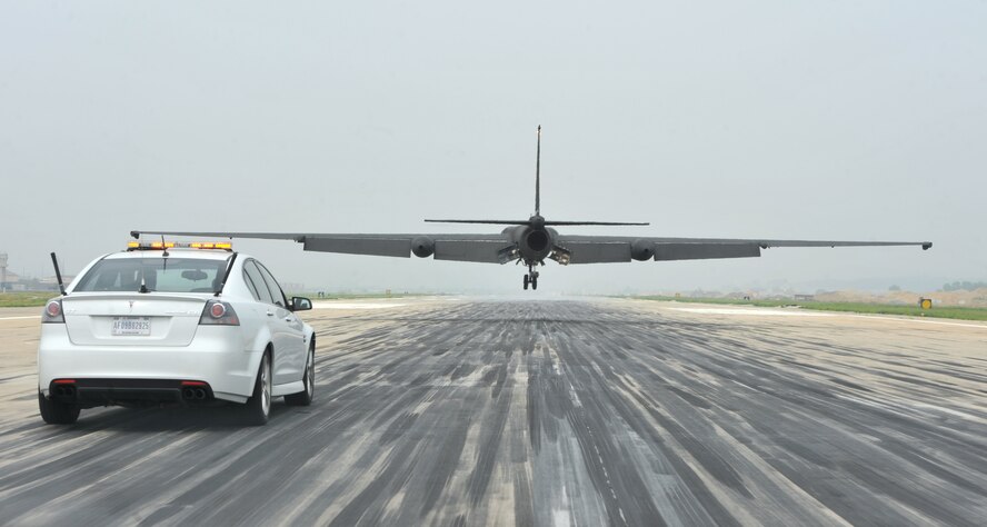 A pilot with the 5th Reconnaissance Squadron advises a pilot landing a U-2 from a chase car on Osan Air Base, Republic of Korea, June 8, 2013. A U-2’s unique shape adds more of a challenge in landing, as the pilot cannot see the distance of his back wheel to the ground. Chase cars driven by U-2 pilots, act as the eyes from the flightline. (U.S. Air Force photo/Senior Airman Alexis Siekert)