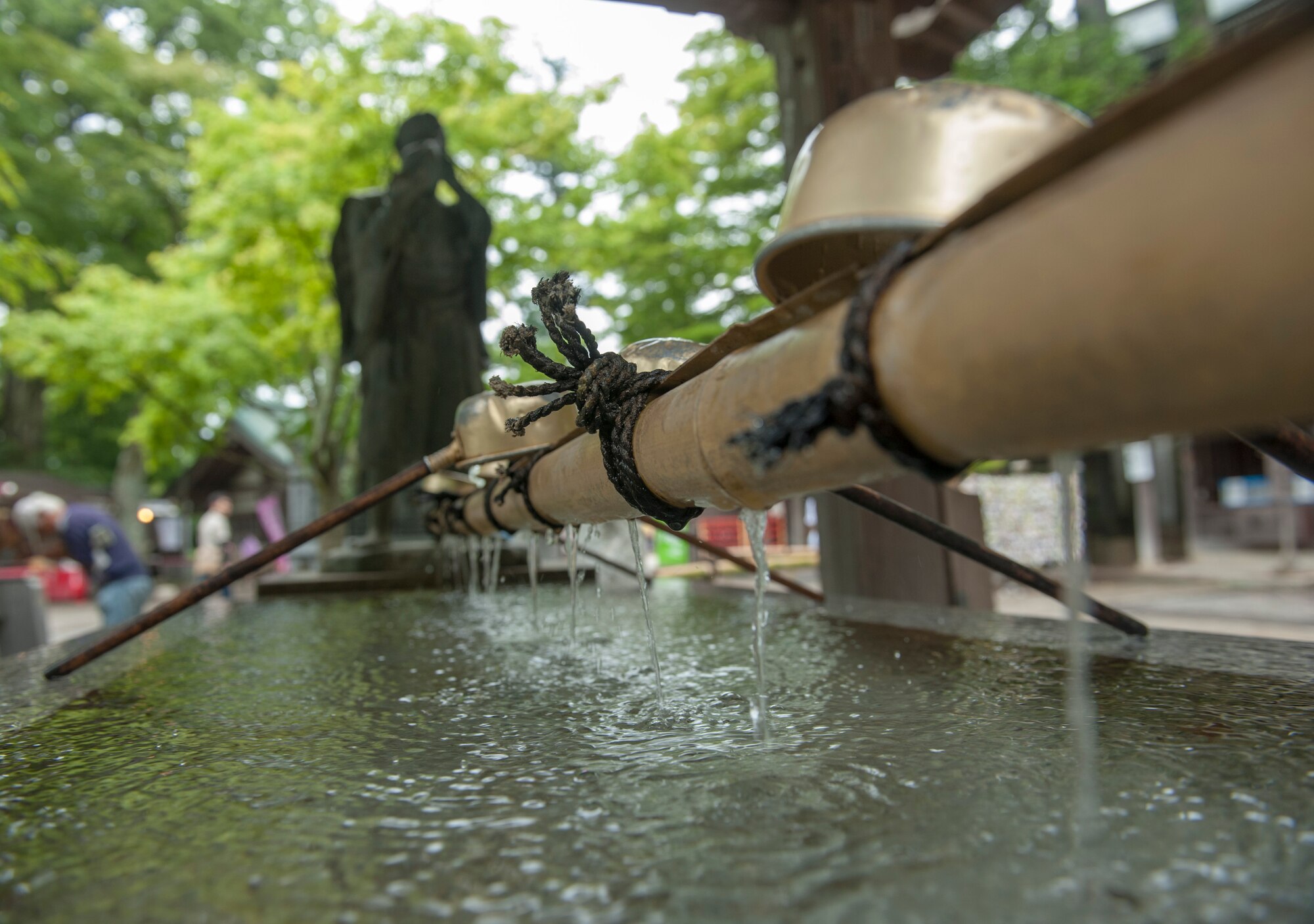 MOUNT TAKAO, Japan -- Water from a fountain flows through bamboo at the entrance of the Yaku-ou-in Temple on Mt. Takao June 10, 2013. When visiting a temple, it is customary to rinse ones hands and mouth as an act of cleansing the body. (U.S. Air Force photo by Senior Airman Michael Washburn/released)