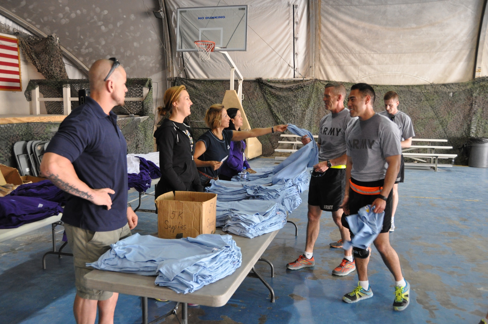 Participants of the Father’s Day 5-kilometer run pick up their t-shirts following the run, which was hosted by the morale, welfare and recreation office on Bagram Airfield, Afghanistan, June 16, 2013. More than 600 runners participated in the event, which was run in honor of deployed fathers. (U.S. Air Force photo/Tech. Sgt. Rob Hazelett)