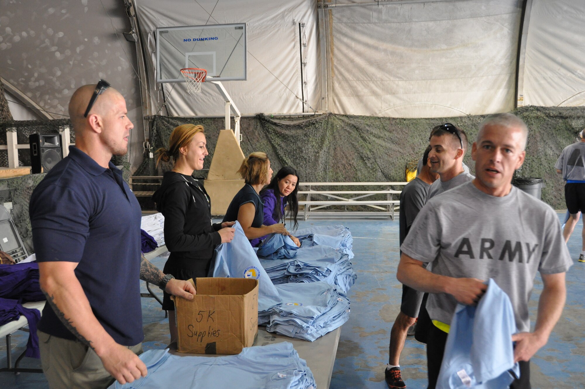 Participants of the Father’s Day 5-kilometer run pick up their t-shirts following the run, which was hosted by the morale, welfare and recreation office on Bagram Airfield, Afghanistan, June 16, 2013. More than 600 runners participated in the event, which was run in honor of deployed fathers. (U.S. Air Force photo/Tech. Sgt. Rob Hazelett)