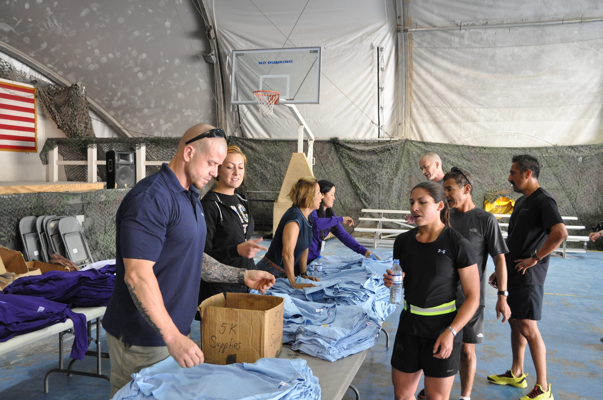 Participants of the Father’s Day 5-kilometer run pick up their t-shirts following the run, which was hosted by the morale, welfare and recreation office on Bagram Airfield, Afghanistan, June 16, 2013. More than 600 runners participated in the event, which was run in honor of deployed fathers. (U.S. Air Force photo/Tech. Sgt. Rob Hazelett)