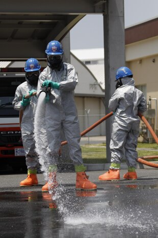Servicemembers donning level-C personal-protective equipment work together to perform the proper operations of vapor suppression during the final exam of the Hazardous Material Awarness and Operations Training held at the station firehouse at Marine Corps Air Station Iwakuni, Japan, June 7, 2013.
