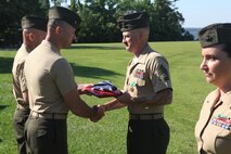 Gunnery Sgt. Ryan P. Clements receives an American flag along with the Navy and Marine Corps Commendation Medal during his retirement ceremony aboard Camp Lejeune, N.C., June 14, 2013. Gunnery Sgt. Clements retired after 20 years of service to the Marine Corps. 