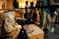 Senior Airman Robert Haog and Staff Sgt. Adam White, 573rd Global Support Squadron, 615th Contingency Response Wing, Air Mobility Command weigh luggage as evacuees of Hurricane Gustav arrive at the Louis Armstrong International Airport, New Orleans, LA., to board flights The Federal Emergency Management Agency and The Department of Defense have chartered  to transport citizens who otherwise could not leave on their own to destinations safely outside the hurricanes path, Aug. 30, 2008. 