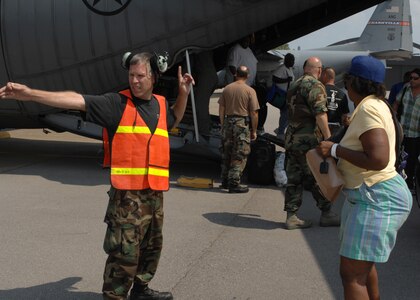 Master Sgt. Daren Smith, Tennessee Air National Guard, directs Hurricane Gustav evacuees off a C-130 and into a hangar, August 31. Four C-130s and aircrews from Dyess Air Force Base, Texas, evacuated more than 400 local residents and critically ill patients from local hospitals. The evacuees were sent to different cities in Tennessee where relief teams were awaiting their arrival with food, water and shelter. 