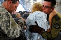 U.S. and Canadian Armed Forces personnel help an evacuee of Hurricane Gustav to board a flight. The U.S. Federal Emergency Management Agency and The Department of Defense chartered to transport citizens to destinations safely outside the hurricanes path Lake Front Airport, New Orleans, La., Aug. 31, 2008. The Canadian Forces aircraft was brought in to help as part of the Civil Assistance Plan between the United States and Canada.