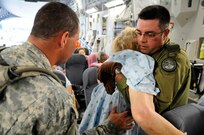 U.S. and Canadian Armed Forces personnel help an evacuee of Hurricane Gustav to board a flight. The U.S. Federal Emergency Management Agency and The Department of Defense chartered to transport citizens to destinations safely outside the hurricanes path Lake Front Airport, New Orleans, La., Aug. 31, 2008. The Canadian Forces aircraft was brought in to help as part of the Civil Assistance Plan between the United States and Canada.