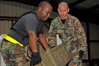 Senior Airman Kenneth Alexander (left) and Capt. Alan Delgado, both members of a Mobile Aeromedical Staging Facility team from MacDill Air Force Base, Fla., unload medical supplies in Corpus Christi, Texas. The MASF team deployed in support of U.S. Northern Command, which is supporting federal, state and local Hurricane Ike response efforts there. 