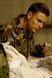 First Lt. Jason Estes, director of operations for the Mobile Aeromedical Staging Facility team based out of MacDill Air Force Base, Fla., tends to a patient waiting for evacuation in Corpus Christi, Texas, Sept. 11. The team worked late into the night helping evacuate patients from a local area hospital. U.S. Air Force aircraft transported patients to safe locations out of Hurricane Ike's path. 