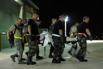 U.S. Air Force Airmen made up of active duty, Guard, and Reserve from multiple Air Force bases load hospital patients onto a C-130 aircraft at the Beaumont Airport in Texas Sept.  12, 2008. Little Rock Air Force Base C-130s were deployed to perform aero medical and transportation missions in preparation for Hurricane Ike's landfall in southern Texas.  
