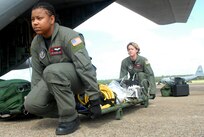 U.S. Air Force Tech. Sgt. Angela Burton and Senior Airman Melinda Ford unload medical equipment from a C-130 at Little Rock Air Force Base, Ark., Sept. 12, 2008.  The Airmen were part of a combined effort from the 61st Air Wing C-130 aircraft and crews from Little Rock Air Force Base and the 908th Aero medical Evacuation Squadron Scott Air Force Base, Ill., to transport medical patients from Beaumont, Texas, to Lackland AFB, Texas, in preparation for Hurricane Ike's landfall in southern Texas.  