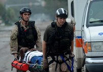 U.S. Air Force Staff Sgt. Lopaka Mounts, left, and Senior Airman Brandon Smith, both pararescueman assigned to the 331st Air Expeditionary Group, transport an injured resident from an ambulance for air evacuation during search and rescue operations in Galveston, Texas, Sept. 13, 2008, following the landfall of Hurricane Ike. 