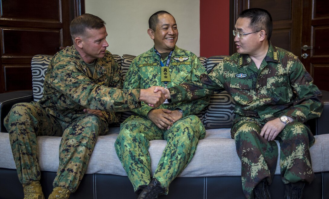 U.S. Marine Corps Colonel Douglas Pasnik left, shares a handshake with Senior Colonel Wu Xihua, Deputy Chief of the Emergency Office, General Staff Headquarters, People's Liberation Army.  Colonel Sahat Hamzah of the host nation Brunei, center, looks on.  Each of these men has a leadership role in the Association of Southeast Asian Nations Defence Ministers Meeting (ADMM) –  ASEAN Humanitarian Assistance/Disaster Relief and Military Medicine Exercise (AHMX) in Brunei.  ADMM-Plus AHMX is a multilateral exercise that provides a forum for regional partner nations to address shared security challenges, strengthen defense cooperation, enhance interoperability and promote stability in the region. The exercise, which is scheduled from June 16 to 20, provides an opportunity for participating nations to hone their communication skills and learn from each other’s’ unique experiences and expertise, better preparing partner nations for a unified approach to future contingencies.