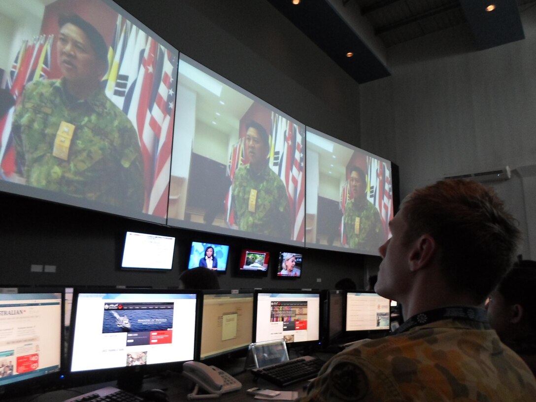 Australian Lt. Luke Ebneter, along with representatives from multiple Asia-Pacific nations, observe the opening ceremony video to the Association of Southeast Asian Nations Humanitarian Assistance/Disaster Relief and Military Medicine Exercise (AHMX) at the Multinational Coordination Centre in Muara, Brunei Darussalam, June 17. More than 2,500 multinational personnel from 18 Asia-Pacific nations are participating in the ASEAN exercise, which provides a platform for regional partner nations to address shared security challenges, strengthen defense cooperation, enhance interoperability and promote stability in the region. Ebneter is an engineer planner with 2nd Combat Engineer Regiment, Australian Defence Force.
