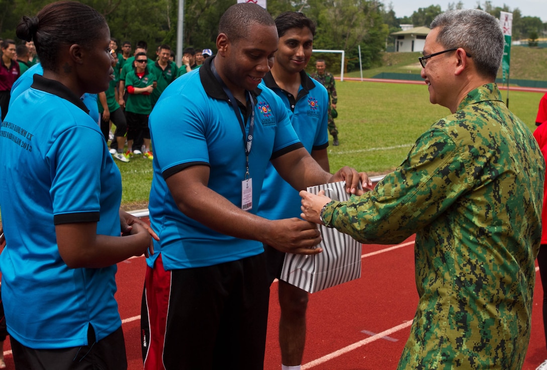 U.S. Navy Petty Officer 2nd Class Victor S. Parker, center, accepts a gift from Royal Brunei Armed Forces Lt. Col. Dr. Mohd Hafizul Hassan, right, on behalf of his team placing second in a tug-of-war competition during a sports field meet at Berakas Army Garrison Camp, Brunei Darussalam, June 14. The competition took place as part of the Association of Southeast Asian Nations Defence Ministers Meeting (ADMM) - Plus ASEAN Humanitarian Assistance/Disaster Relief and Military Medicine Exercise (AHMX). Parker is a hospital corpsman with the Naval Environmental Preventive Medicine Unit 6. Hassan is the chief medical officer for the exercise.