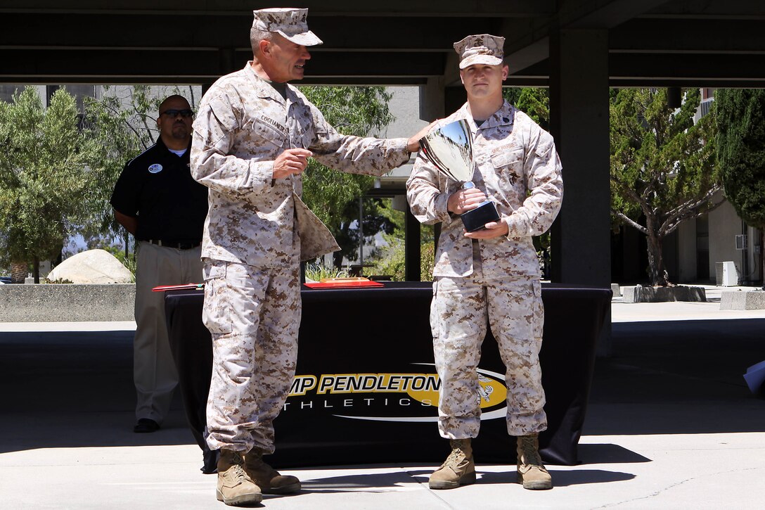 Brig. Gen. Vincent A. Coglianese presents Staff Sgt. Cody A. Lefever with a trophy as an award for becoming the 2012 Camp Pendleton Athletics male athlete of the year here June 17. Lefever started training for the sport of powerlifting in the summer of 2011. Lefever is also an advocate for the sport of powerlifting, having helped train five lifters to compete, two of which already have competed, and three others are training for an up-coming powerlifting meet. Coglianese is the base commanding general and regional authority for five Marine Corps Installations in the southwestern United States. Capt. Rebecca L. Wilkinson, who is presently deployed, has achieved the title of 2012 female athlete of the year.
