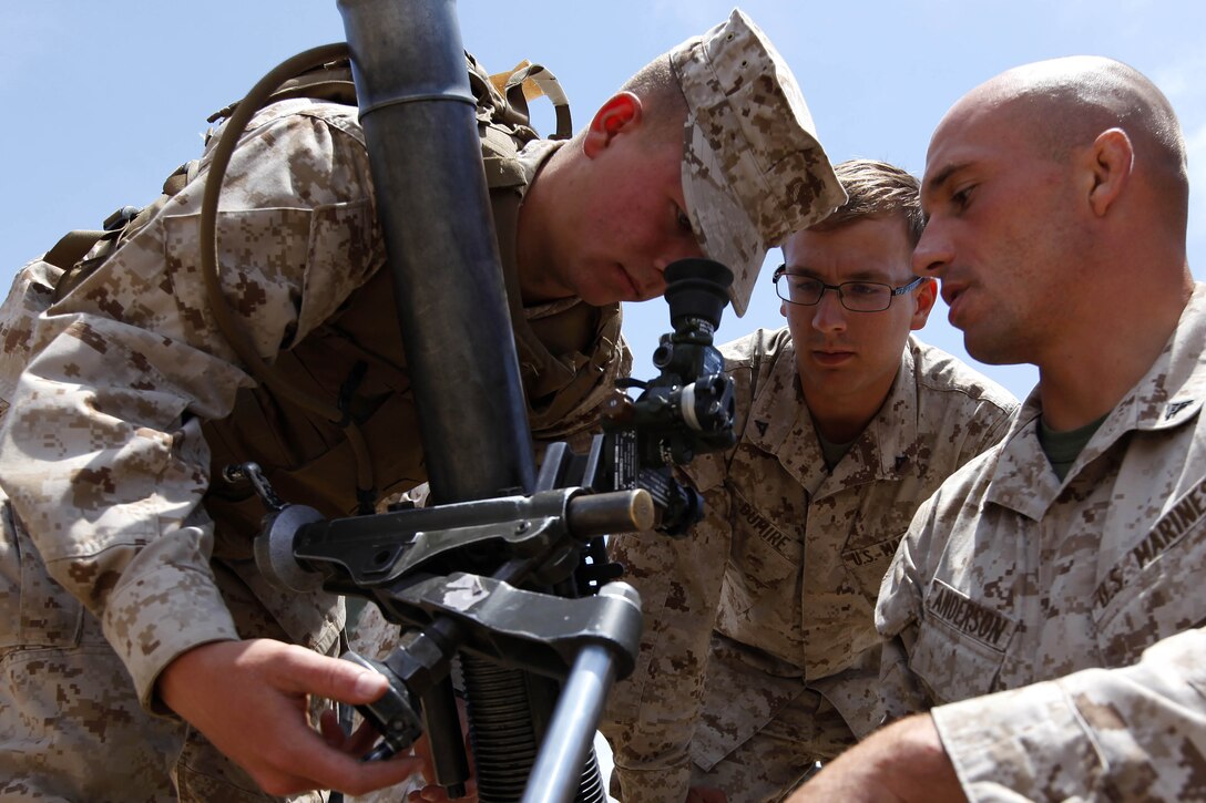 Midshipman 3rd Class Ty Gunnlaugsson, left, adjusts an 81-millimeter mortar cannon with help from Lance Cpl. Levon Dumire, center, and Lance Cpl. Seth Anderson, right, during Marine Week of Career Orientation and Training for Midshipmen-West 2013 here June 12. Future officers from across the U.S. participated in the four-weeks of training designed to introduce them to career opportunities. Dumire and Anderson are infantry motormen with 2nd Battalion, 1st Marines, 1st Marine Division here.