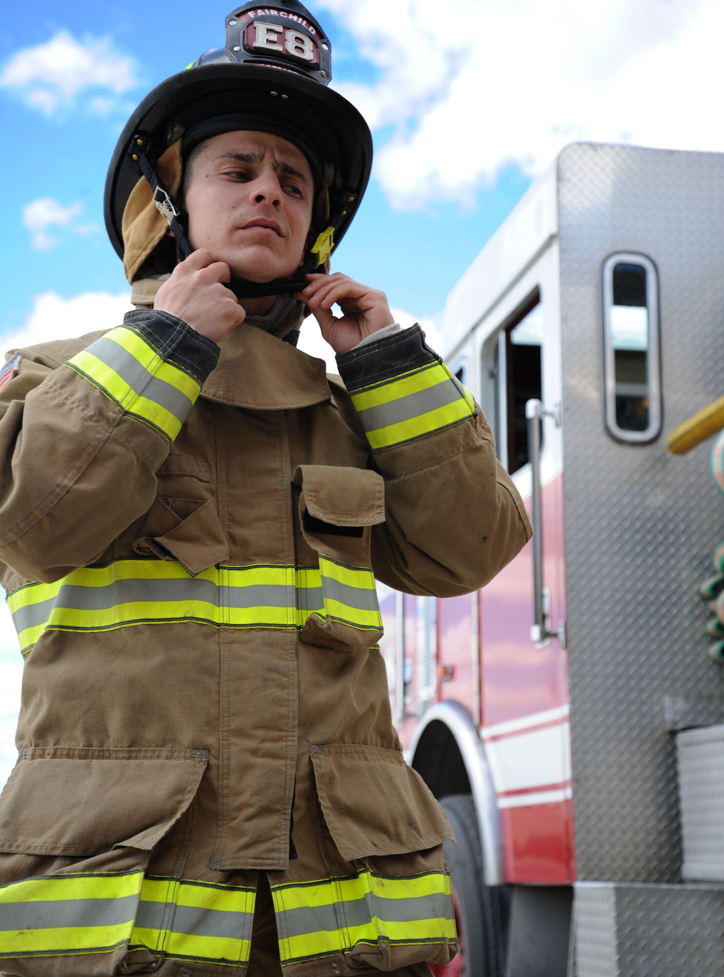Senior Airman Alberto Garcia-Vidal, 92nd Civil Engineer Squadron firefighter, practices donning his personal protective equipment to ensure safety while demonstrating firefighting activities at Fairchild Air Force Base, Wash., June 12, 2013. The structural gear is rated to withstand temperatures up to 1200 degrees in most situations. (U.S. Air Force photo by Airman 1st Class Janelle Patiño/Released)