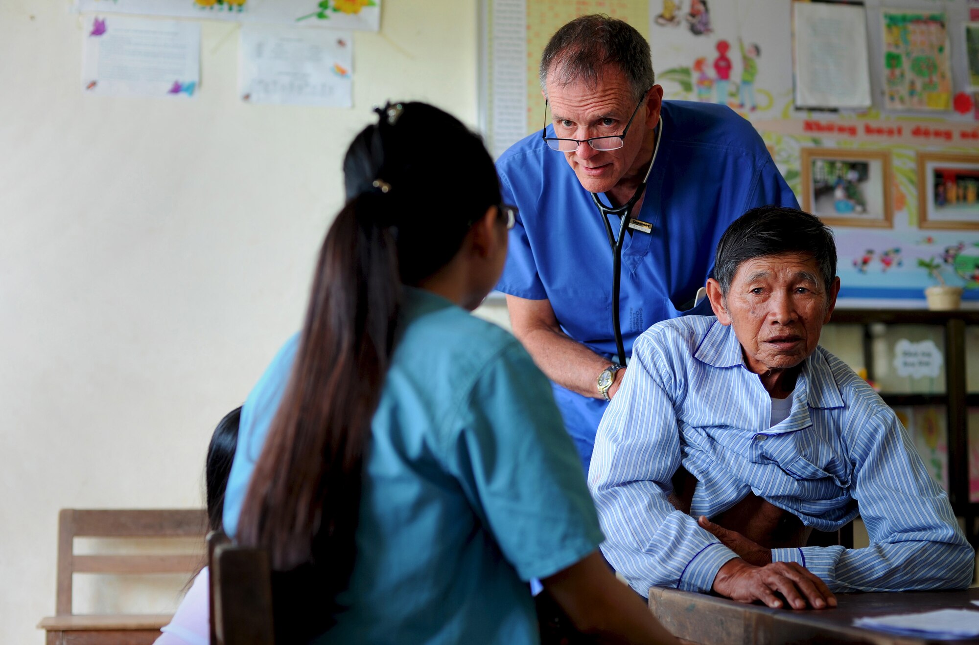 U.S. Air Force Col. Bob Gentry, State Air Surgeon for Oregon Air National Guard, examines a patient as part of the Health Service Outreach Program during Operation Pacific Angel 13-3 in Dong Hoi, Quang Binh Province, Vietnam, June 15, 2013. General medicine was one of the various medical services offered as part of the Health Services Outreach program during the reoccurring humanitarian mission. Operation PACANGEL is a joint and combined humanitarian assistance exercise held in various countries several times a year and includes medical, dental, optometry, engineering programs and a variety of subject-matter expert exchanges. (U.S. Air Force photo by Staff Sgt. Sara Csurilla)
