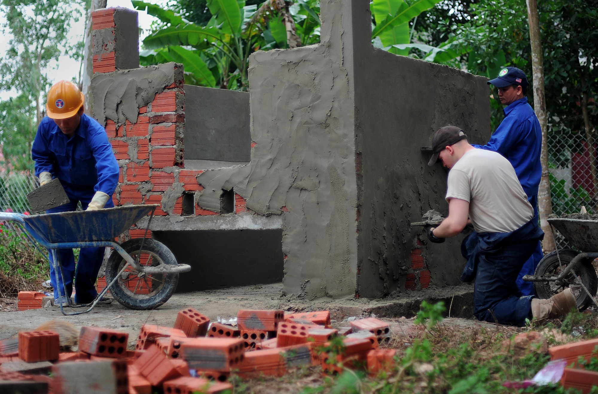 Construction workers with Vietnam People's Army and a U.S. Army Soldier build an incinerator that will be used to burn medical waste, as part of the Engineering Civil Action Programs for Operation Pacific Angel 13-3 in Dong Hoi, Quang Binh Province, Vietnam, June 12, 2013. U.S. and Vietnam military members joined together to complete construction projects on one medical clinic and two schools in Vietnam. Operation PACANGEL is a joint and combined humanitarian assistance exercise held in various countries several times a year and includes medical, dental, optometry, engineering programs and a variety of subject-matter expert exchanges. (U.S. Air Force photo by Staff Sgt. Sara Csurilla)

